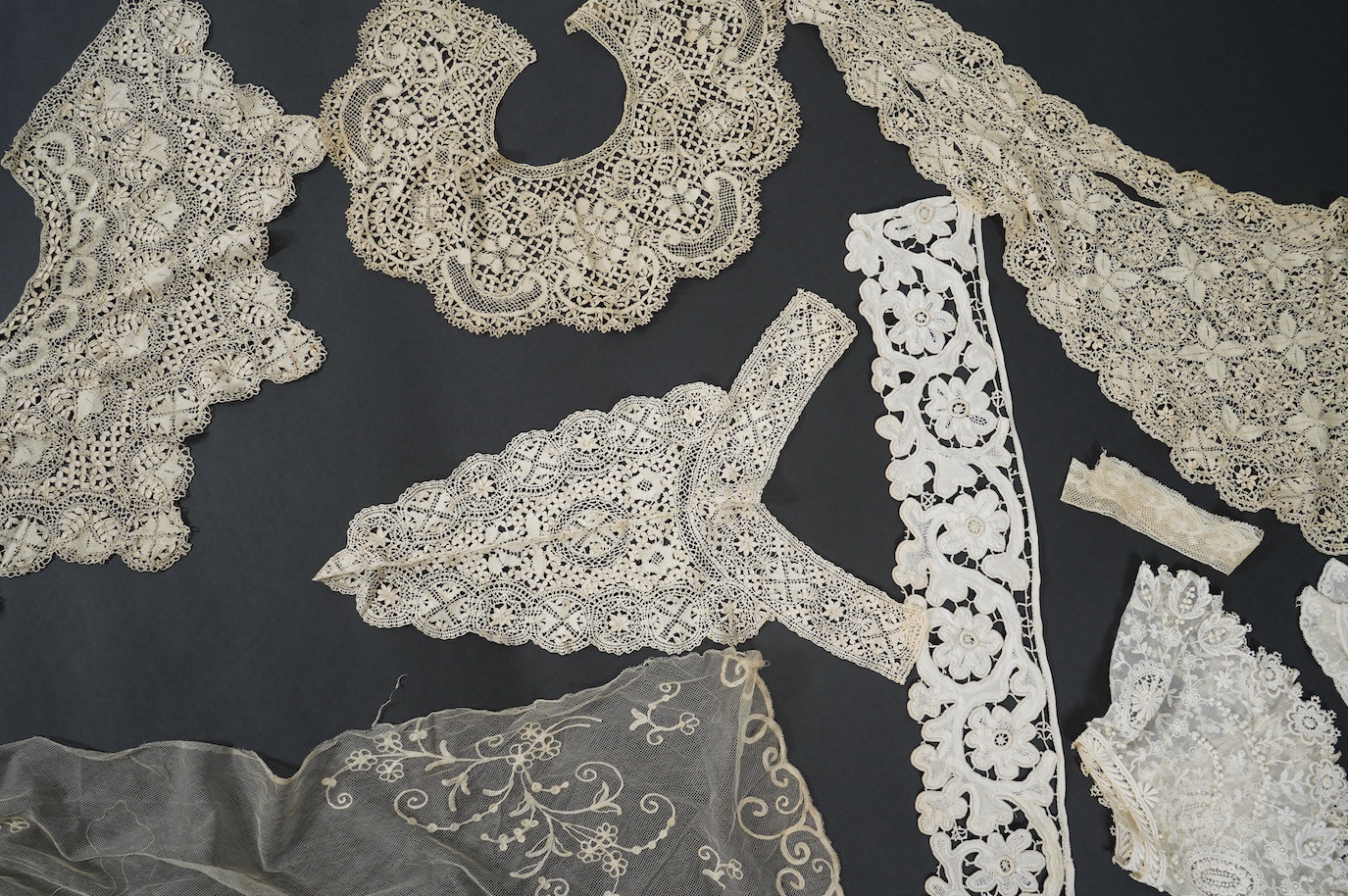A needle run embroidered net skirt, a similar Bertha, five large silk Maltese bobbin lace collars and trimming, a length of Venetian style lace, mittens etc. Condition - good